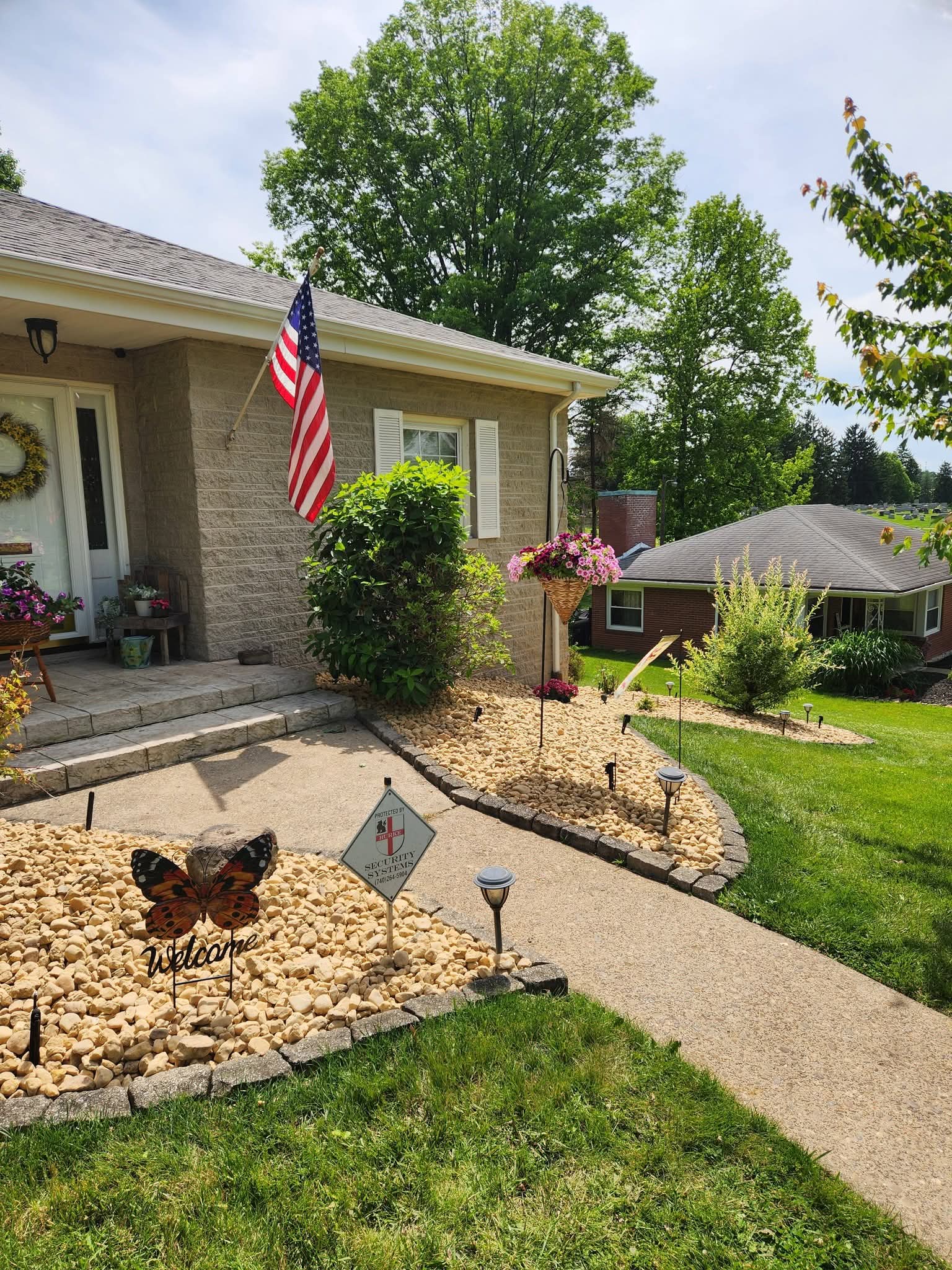 Fresh river rock beds with block edging along a front walkway